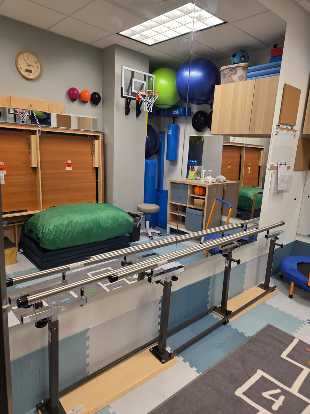 Balance bars and a hopscotch mat in the therapy gym